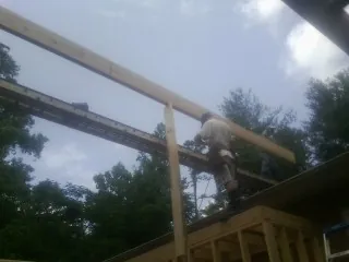 Carpenter setting a ridge beam over a new addition frame — Ice Dam Removal by Roofing Brothers in New Oxford