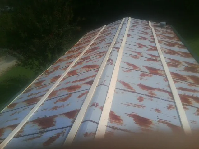 Rusted metal roof panels with new wood purlins before replacement — Storm Damage Roof Repair in New Oxford by Roofing Brothers