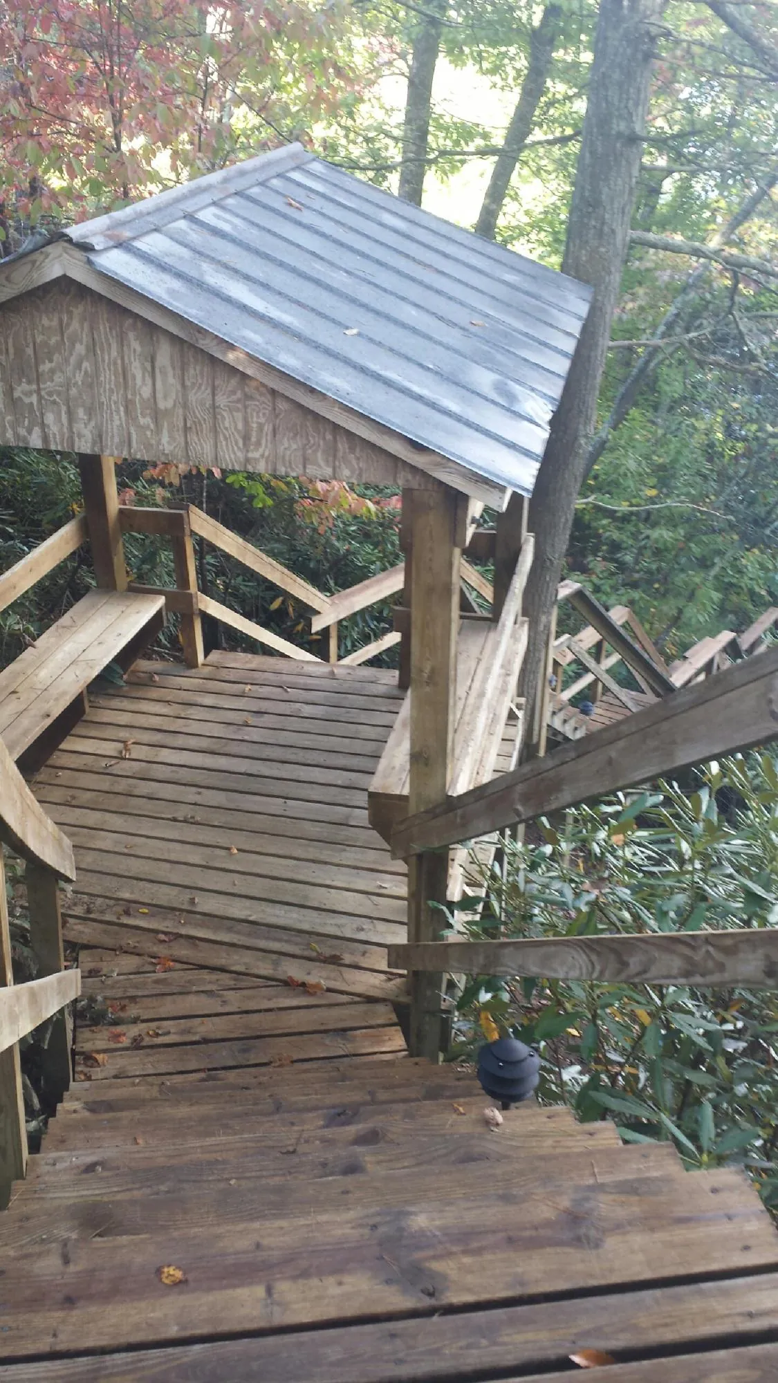 Metal roofed shelter over wooden steps on a wooded walkway — Skylight Repair & Installation work by our crew in New Oxford